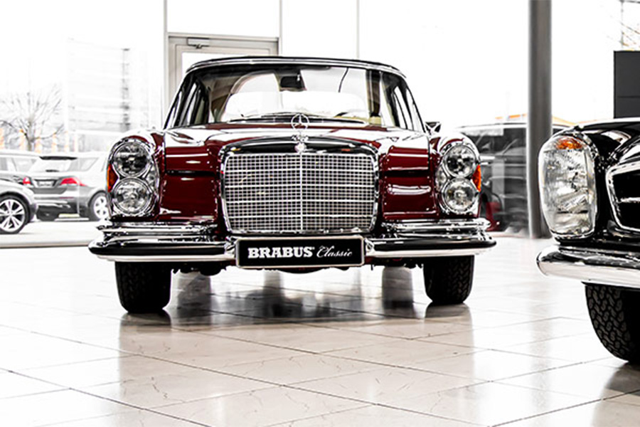 Klassischer BRABUS Mercedes-Benz im Showroom, frontal fotografiert, glänzend rot und chrom.