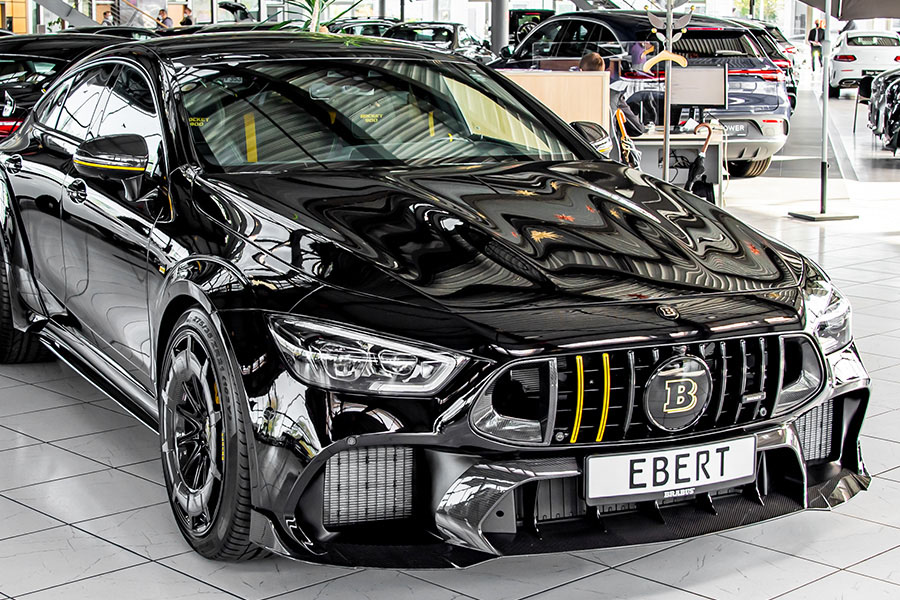 Schwarzer BRABUS AMG mit gelben Akzenten in edlem Autohaus, sportlich-aggressives Design.