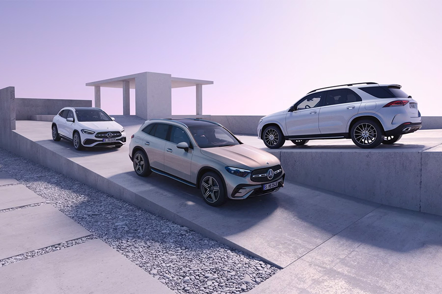 Drei Mercedes-Benz SUV-Modelle stehen auf versetzten Betonplattformen in einer minimalistisch gestalteten, modernen Kulisse bei weichem, violettem Licht. Links ein weißer GLA, in der Mitte ein beiger GLB, rechts ein weißer GLE.