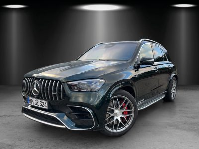 Dunkelgrüner SUV in Studiobeleuchtung, schräg von vorn links fotografiert, mit markanter Frontpartie, vertikalem Kühlergrill, roten Bremssätteln und großen Leichtmetallfelgen.